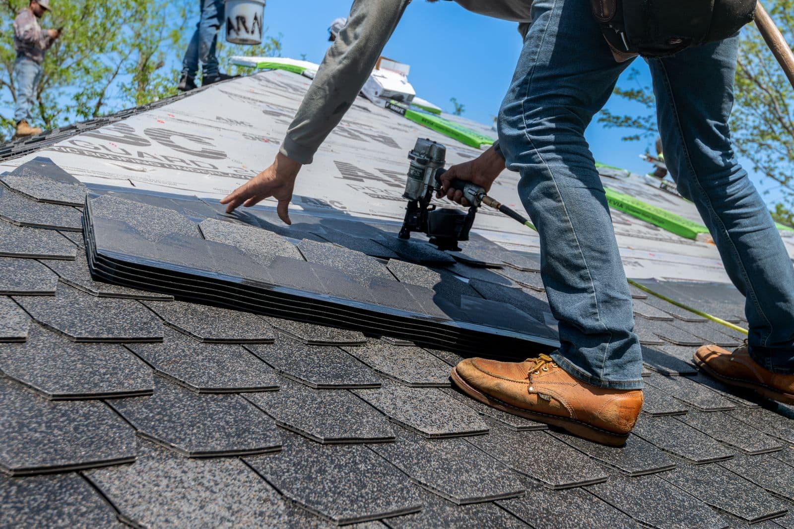 Roofing crew installing new shingles on a residential roof